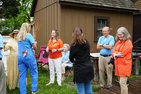 A group of Extension staff and volunteers visiting and conversing at an outdoor event
